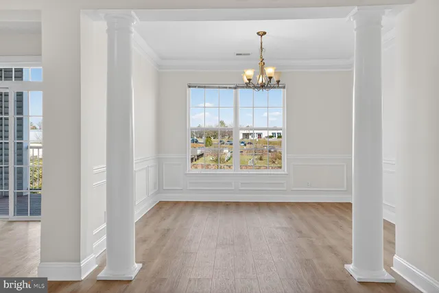 a dining room with furniture a chandelier and wooden floor