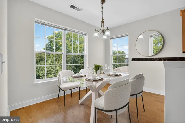 a dining room with furniture a chandelier and wooden floor