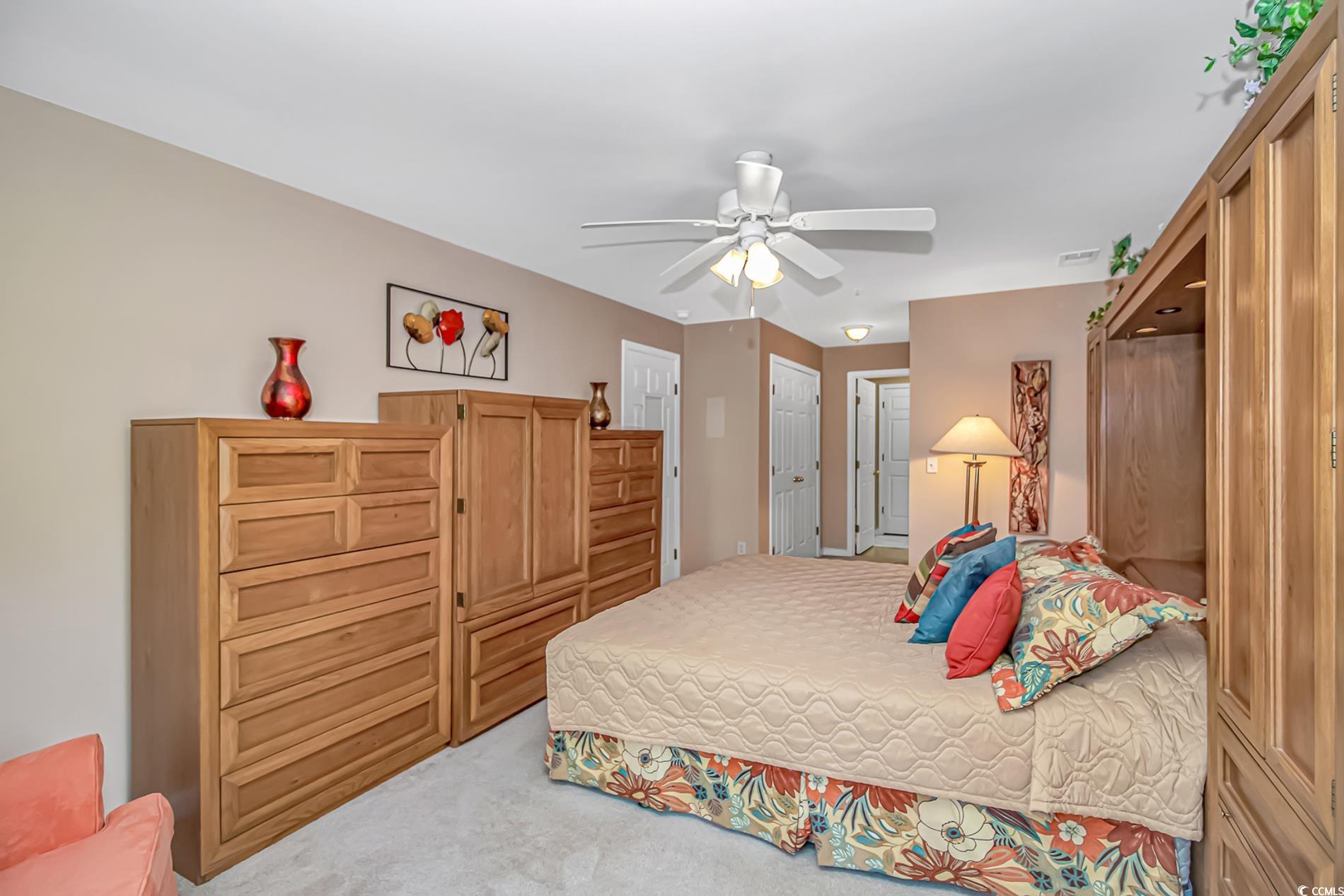 4366 Rivergate Lane, Unit 306 Little River, SC 29566 - Photo 13 of 32 Bedroom with light colored carpet and a ceiling fan