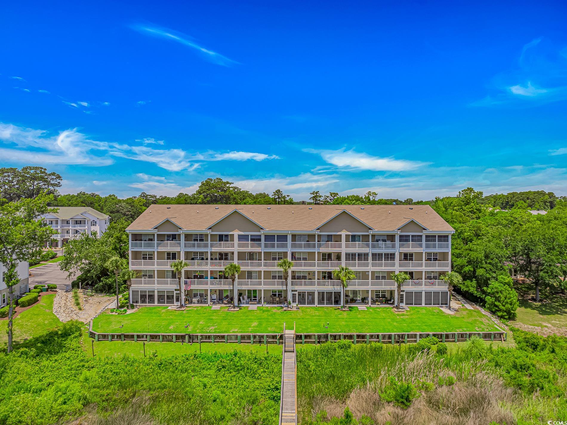 4366 Rivergate Lane, Unit 306 Little River, SC 29566 - Photo 28 of 32 View of building exterior with a fenced backyard
