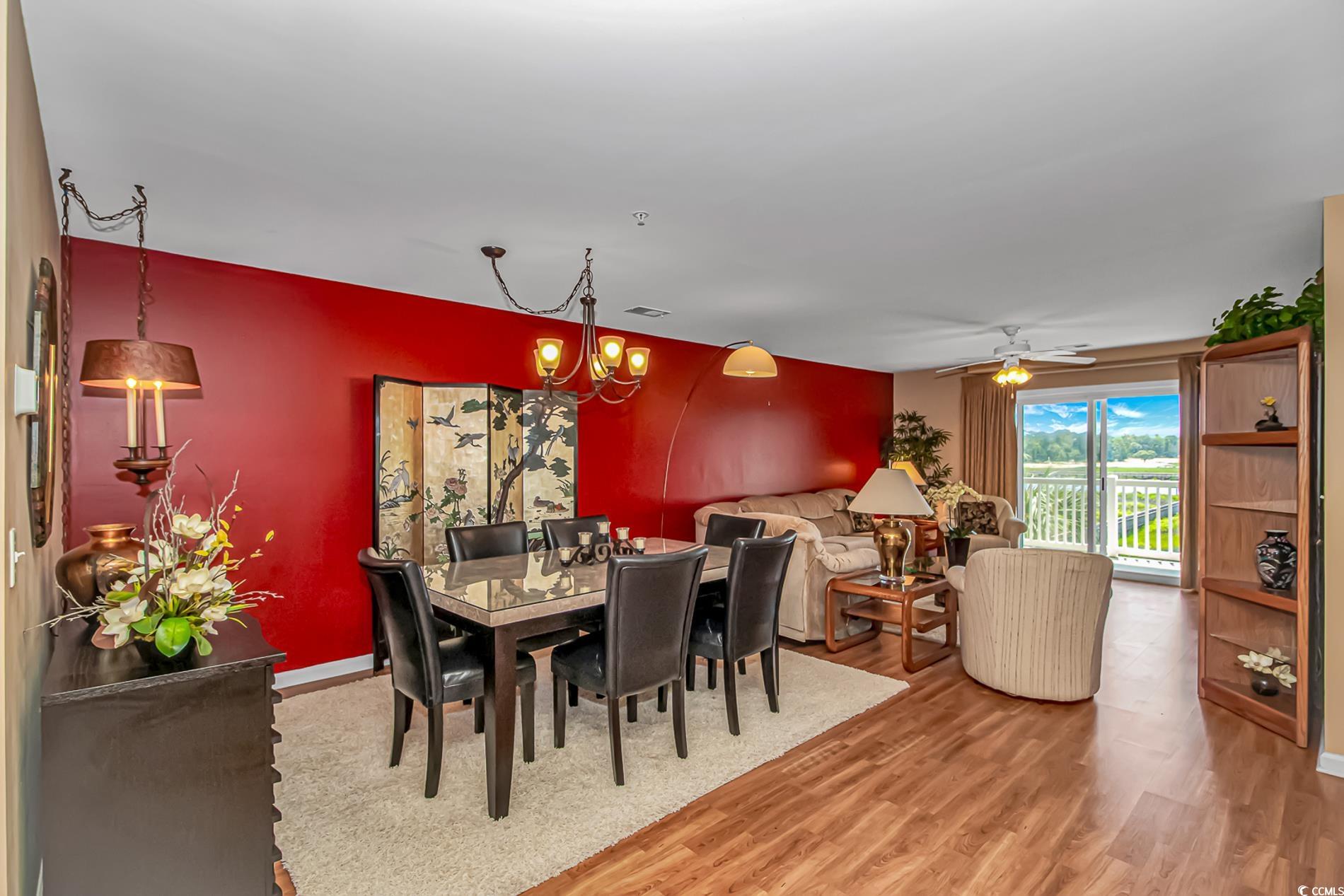 4366 Rivergate Lane, Unit 306 Little River, SC 29566 - Photo 3 of 32 Dining area with light wood-style floors, a chandelier, and a ceiling fan