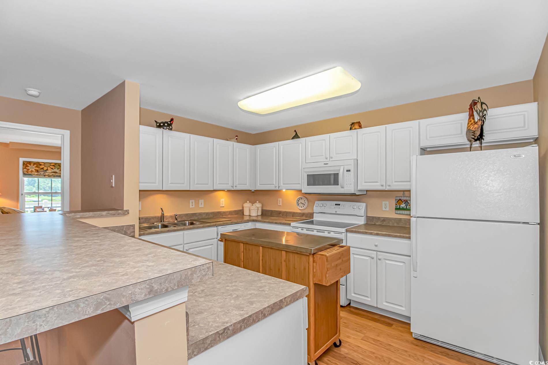 4366 Rivergate Lane, Unit 306 Little River, SC 29566 - Photo 4 of 32 Kitchen featuring white appliances, white cabinets, a peninsula, and light wood-style flooring