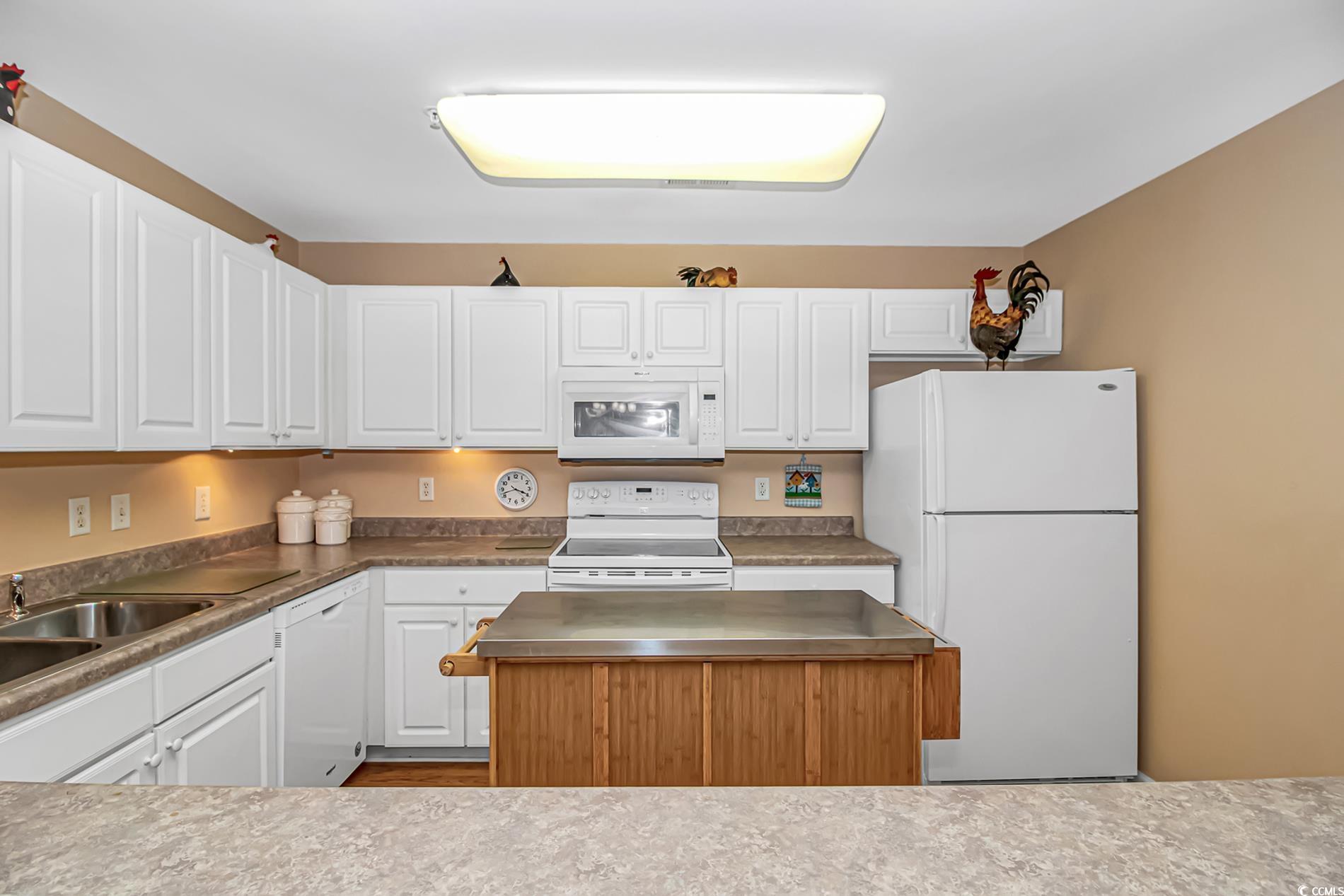 4366 Rivergate Lane, Unit 306 Little River, SC 29566 - Photo 6 of 32 Kitchen with white appliances, white cabinets, and a kitchen island