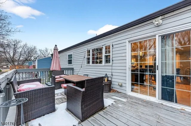 a view of a patio with couches and table and chairs with wooden floor and fence