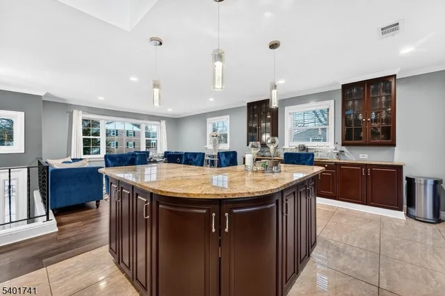 a room with stainless steel appliances granite countertop a sink a counter space and wooden floor