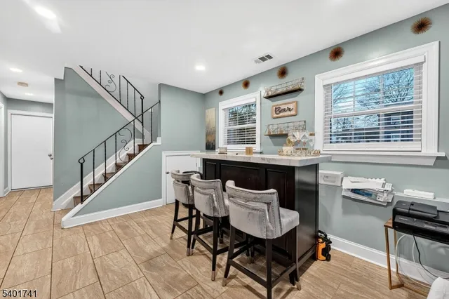 a room with lots of white furniture and wooden floor
