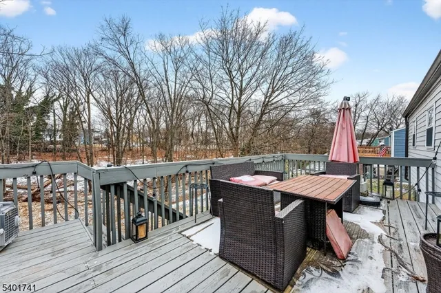 a view of a patio with table and chairs with wooden floor and fence