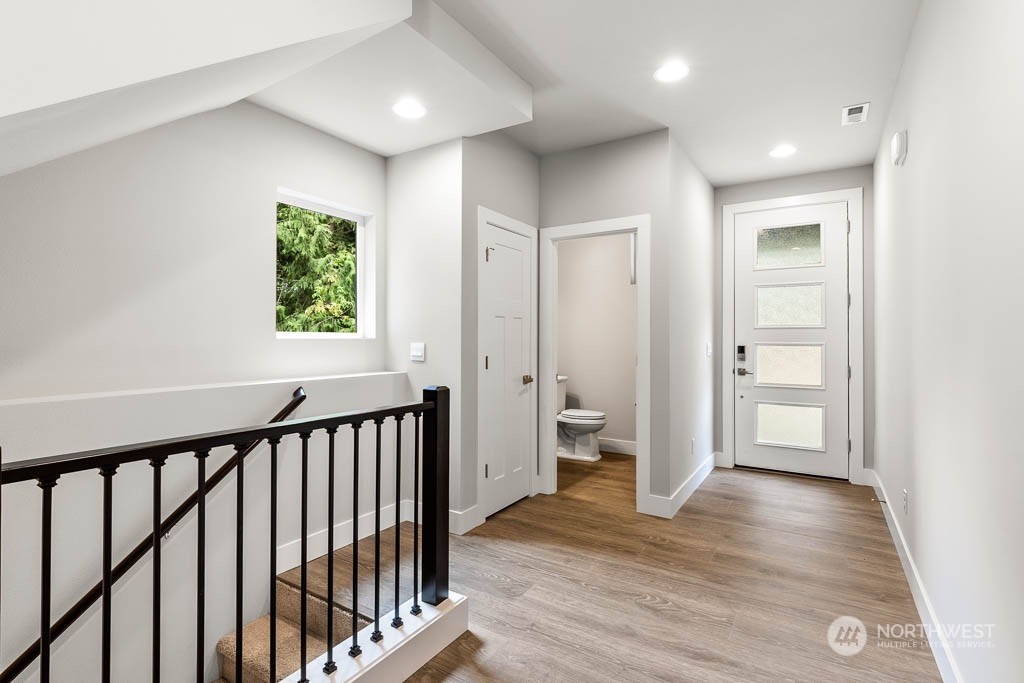 21423 Royal Anne Road, Unit RM1 Bothell, WA 98021 - Photo 20 of 26 a view of a hallway with a bedroom having wooden floor