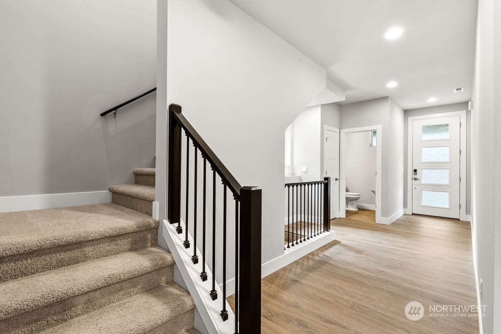 21423 Royal Anne Road, Unit RM1 Bothell, WA 98021 - Photo 23 of 26 a view of a hallway with wooden floor and staircase