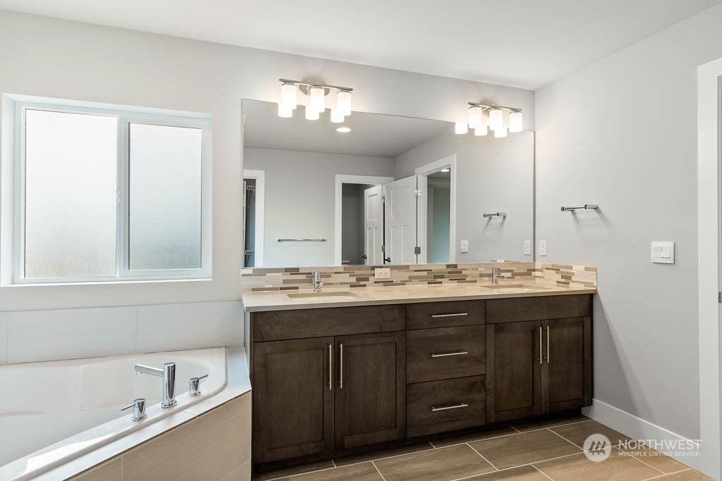 21423 Royal Anne Road, Unit RM1 Bothell, WA 98021 - Photo 9 of 26 a bathroom with a granite countertop sink a large mirror and a bathtub