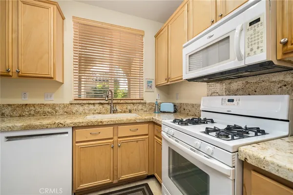 a kitchen with granite countertop cabinets stainless steel appliances and a sink