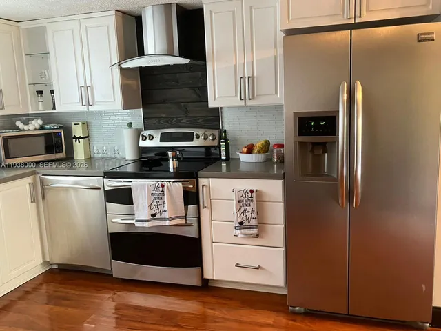 a kitchen with stainless steel appliances a refrigerator stove and microwave