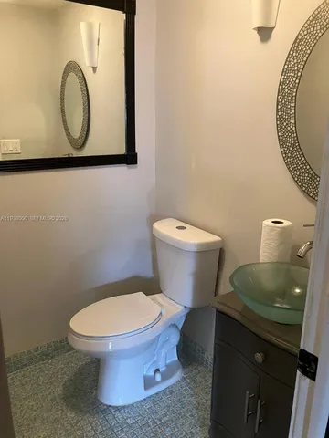 a bathroom with a toilet and a mirror