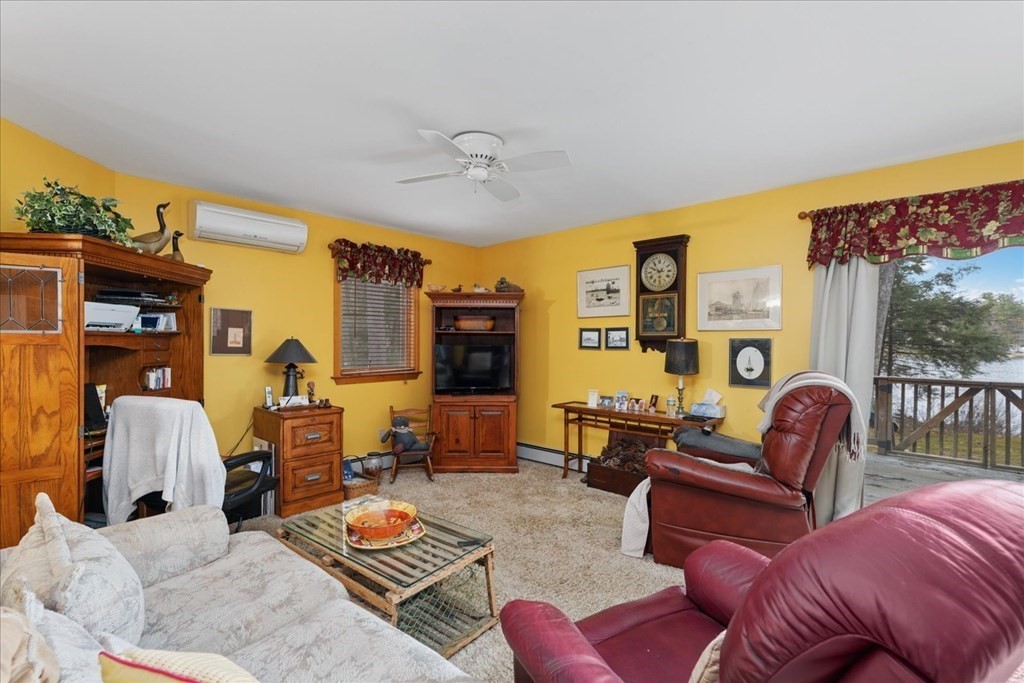 68 Jowders Cove Road Rindge, NH 03461 - Photo 11 of 22 a living room with furniture ceiling fan and a rug
