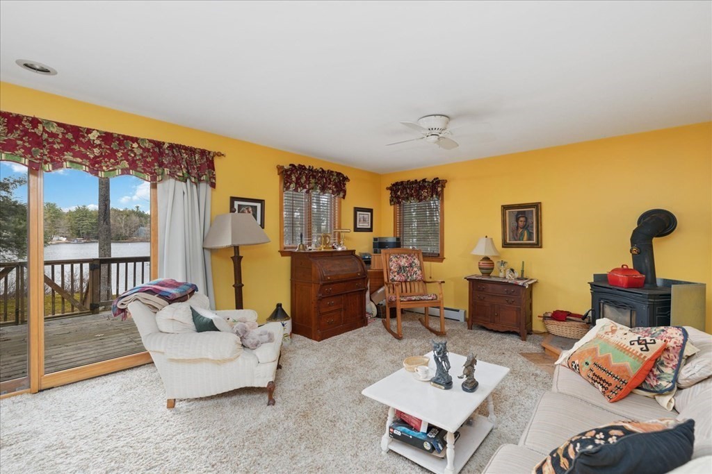68 Jowders Cove Road Rindge, NH 03461 - Photo 12 of 22 a living room with furniture fireplace and a large window