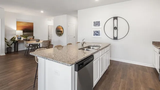 a kitchen with a sink a counter space and wooden floor