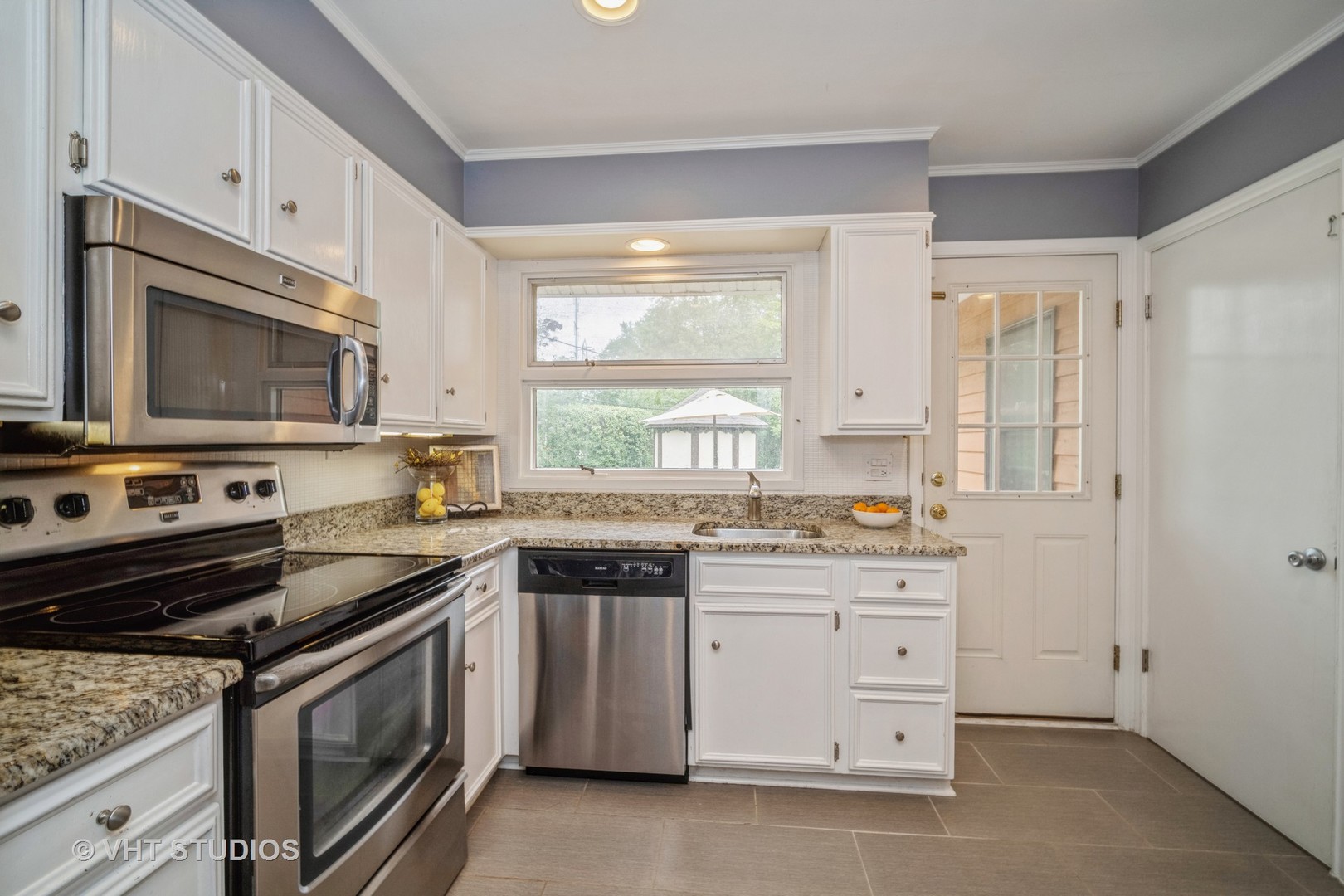 911 Dell Road Northbrook, IL 60062 - Photo 5 of 17 a kitchen with granite countertop a stove sink and microwave