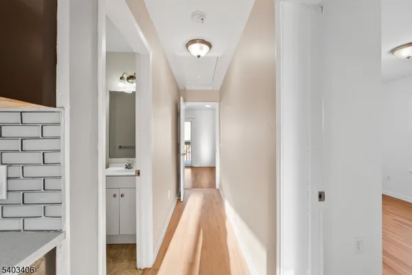 a view of a hallway with wooden floor and staircase