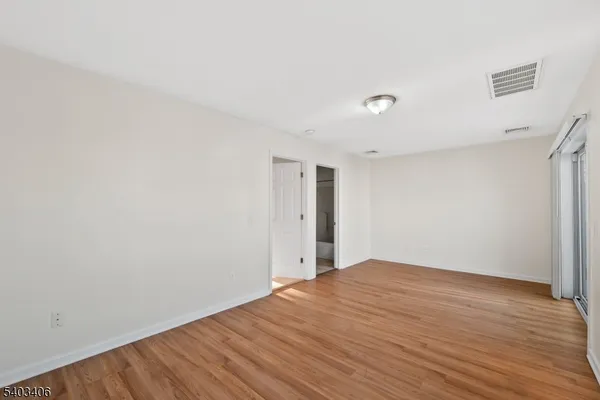 a view of an empty room with wooden floor