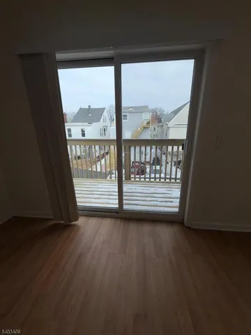 a view of a room with wooden floor and a window