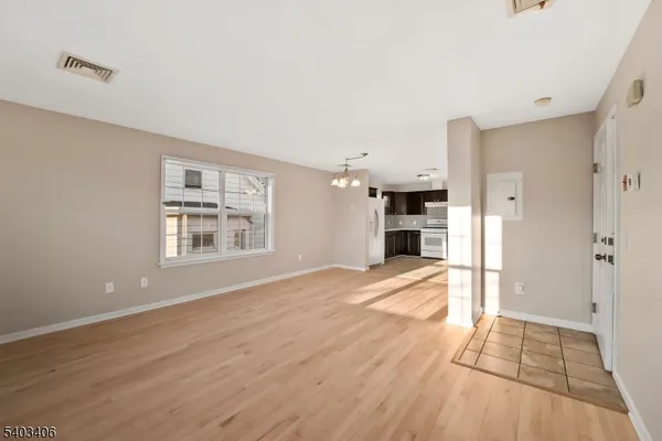 a view of empty room with wooden floor and fireplace