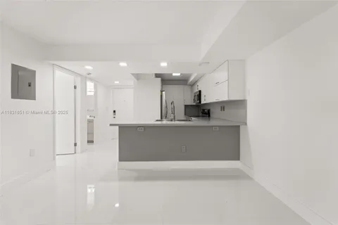 a view of kitchen with stainless steel appliances refrigerator sink and cabinets