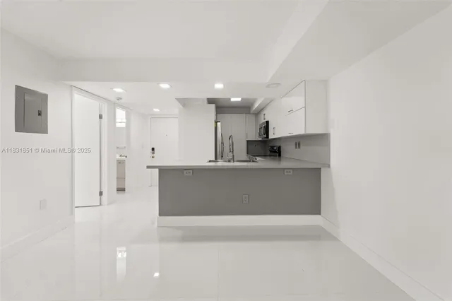 a view of kitchen with stainless steel appliances refrigerator sink and cabinets
