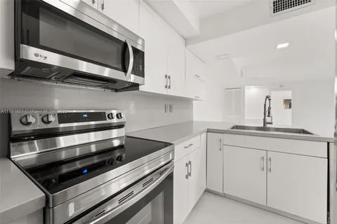 a kitchen with stainless steel appliances white cabinets and a stove top oven