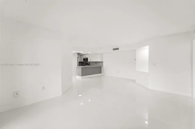 a view of a kitchen with a sink and refrigerator