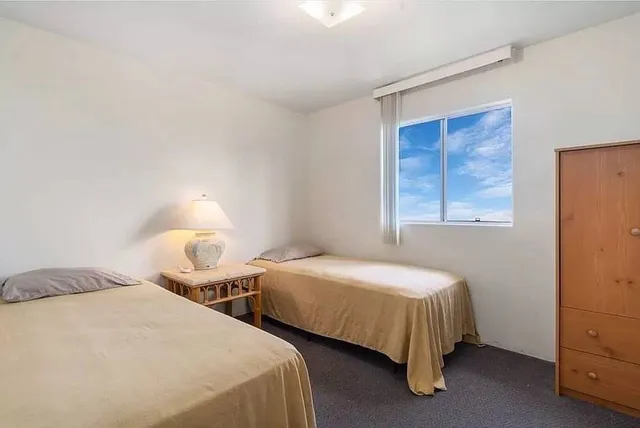 a bedroom with two bed and a window