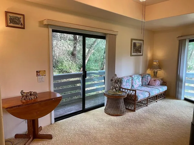 a living room with furniture and a floor to ceiling window