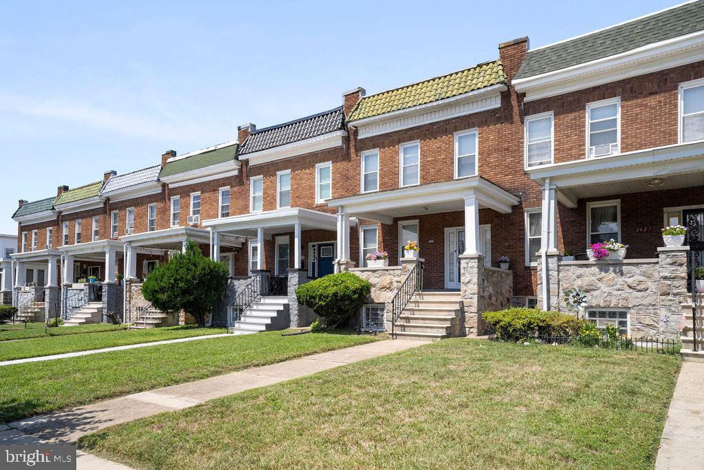 2424 West Lafayette Avenue Baltimore, MD 21216 - Photo 1 of 19 front view of a brick house with a yard