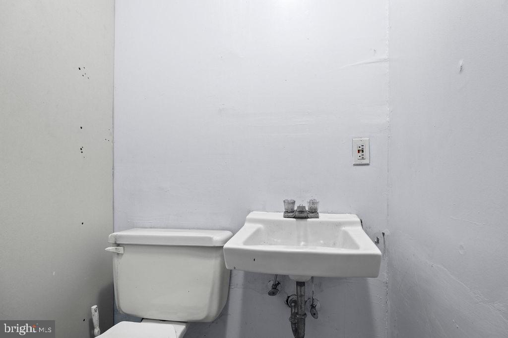 2424 West Lafayette Avenue Baltimore, MD 21216 - Photo 13 of 19 a bathroom with a sink a toilet and a mirror