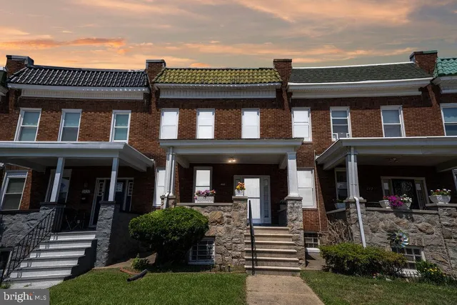 front view of a brick house with a yard