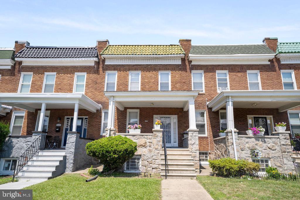2424 West Lafayette Avenue Baltimore, MD 21216 - Photo 3 of 19 front view of a brick house with a yard