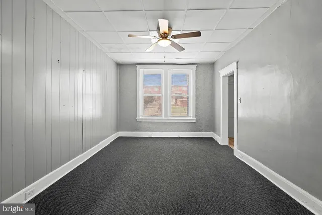 an empty room with chandelier fan