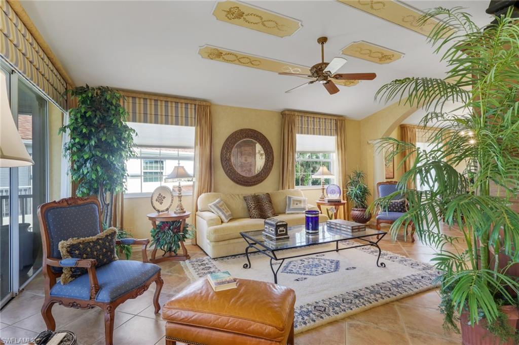 10801 Crooked River Road, Unit 203 Estero, FL 34135 - Photo 7 of 27 a living room with patio a clock on wall and a large window