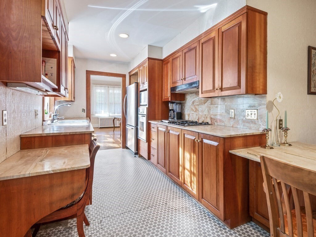 19 Kenilworth Road Worcester, MA 01602 - Photo 17 of 42 a kitchen with stainless steel appliances granite countertop wooden cabinets a sink and dishwasher a stove top oven with wooden floor