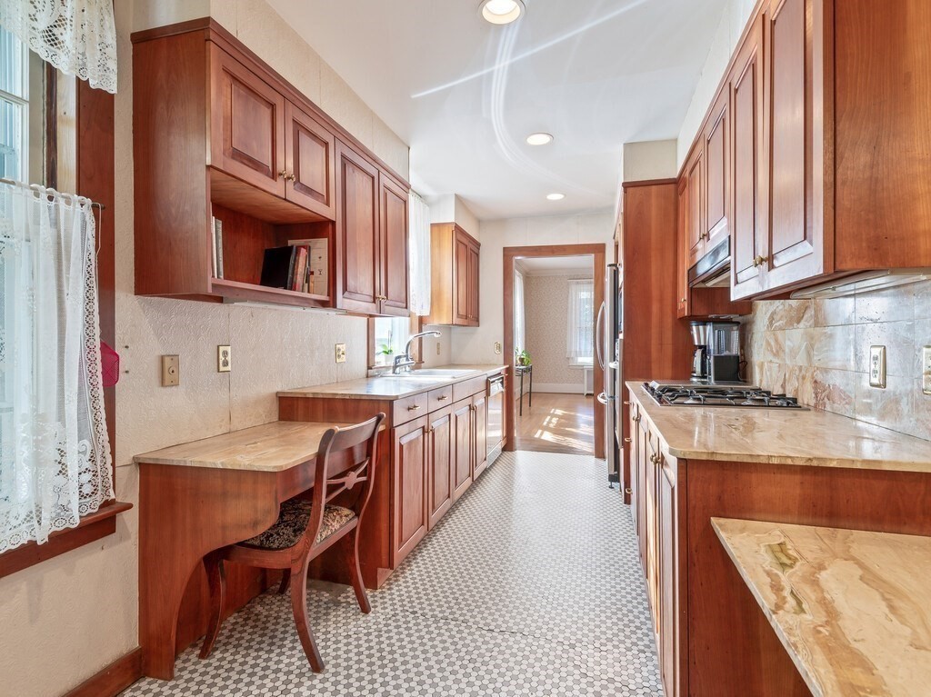 19 Kenilworth Road Worcester, MA 01602 - Photo 18 of 42 a kitchen with stainless steel appliances granite countertop a stove a sink dishwasher a dining table and chairs with wooden floor