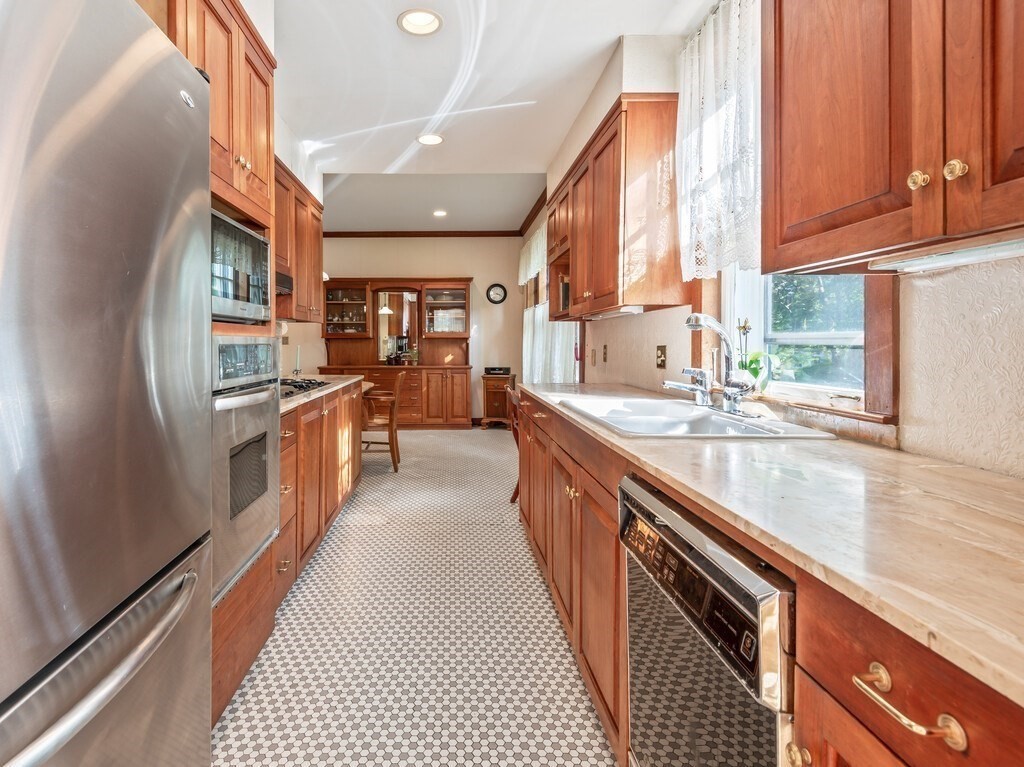 19 Kenilworth Road Worcester, MA 01602 - Photo 19 of 42 a kitchen with stainless steel appliances granite countertop a refrigerator a sink dishwasher a stove and white countertops with wooden floor