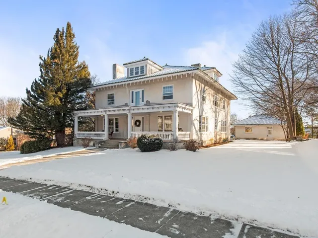 a view of a house with a yard covered in snow