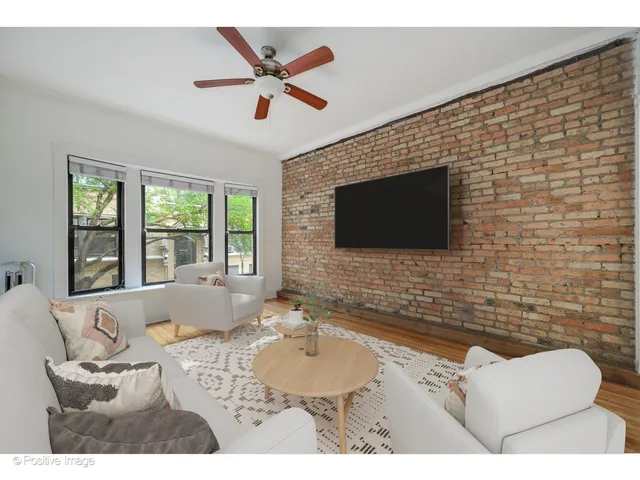 a living room with couches a flat screen tv and a fireplace