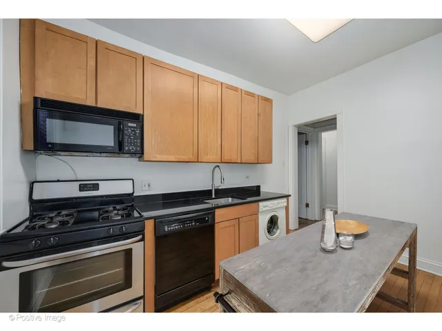 a kitchen with stainless steel appliances a stove microwave and sink