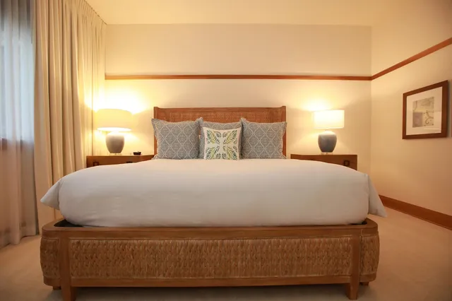 a large bed sitting in a bedroom next to a window