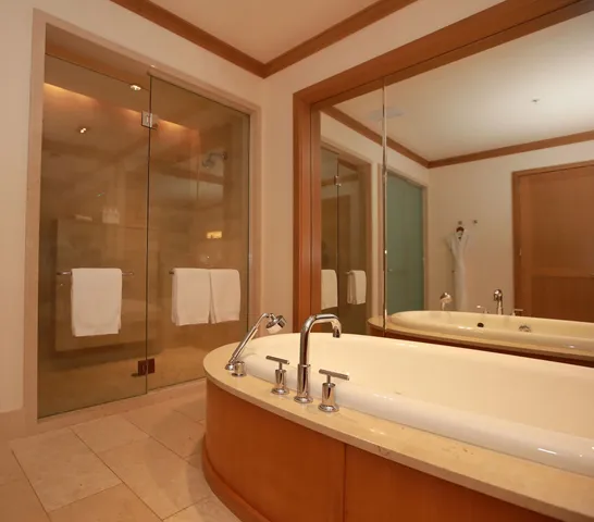 a bathroom with a tub sink and mirror