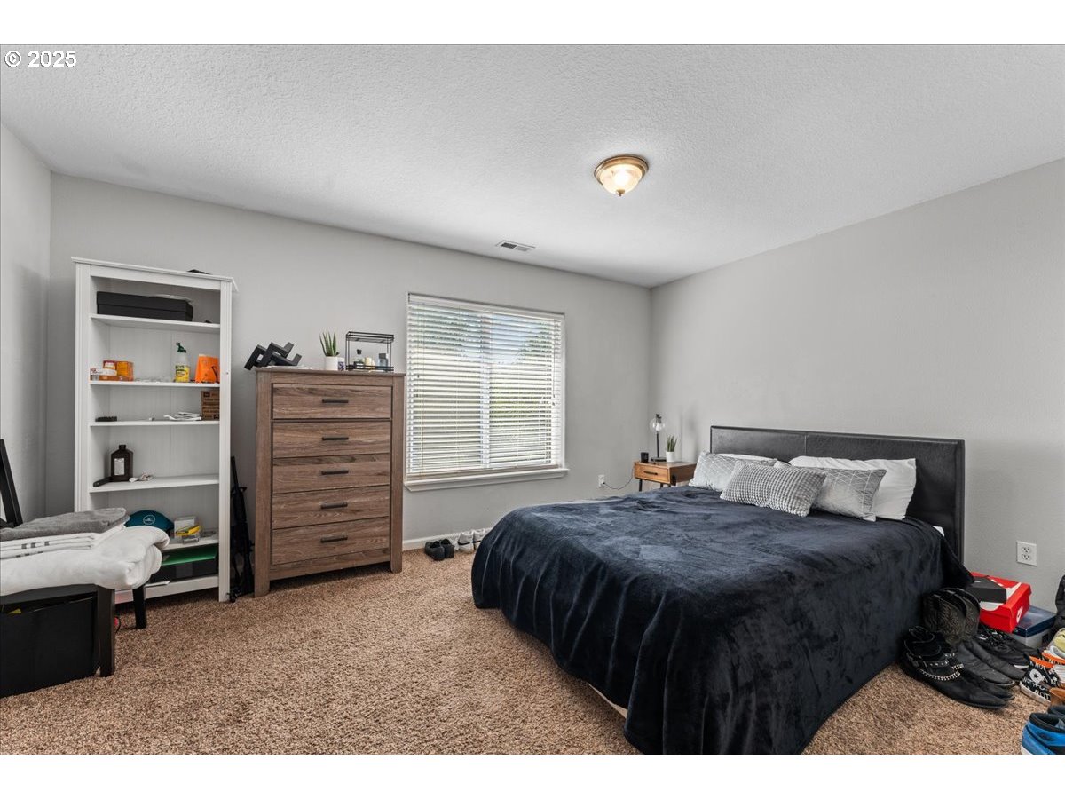 5122 Southeast Jenne Road Portland, OR 97236 - Photo 33 of 36 a bed room with a bed and a chair