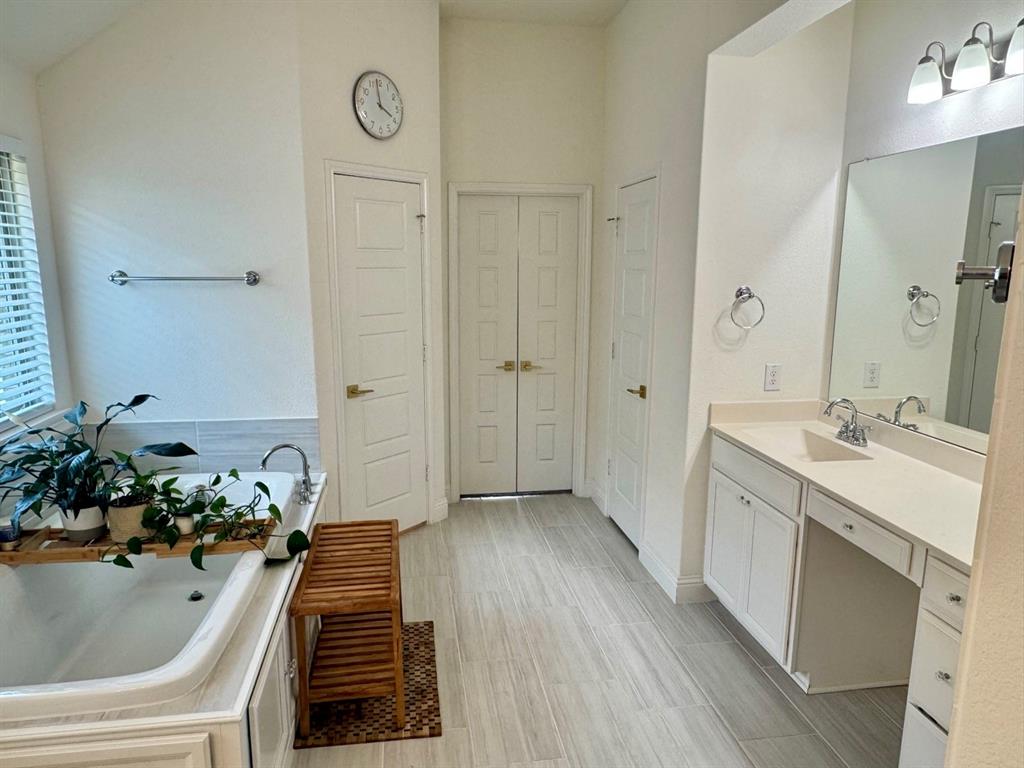 7024 Tree Stand Point Little Elm, TX 76227 - Photo 14 of 30 a bathroom with a tub sink and mirror