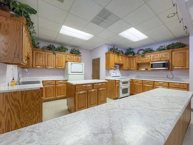 a large kitchen with stainless steel appliances wooden cabinets and a counter top