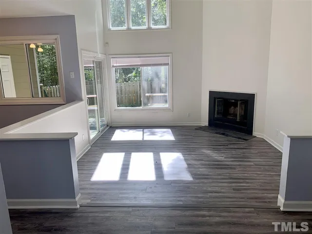 a view of an empty room with window and fire place