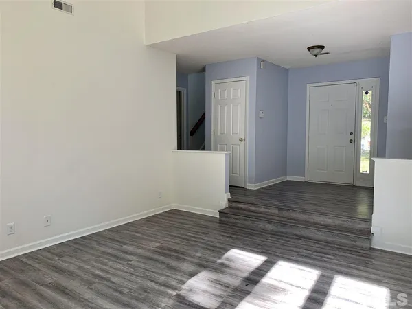 a view of a room with wooden floor and bench